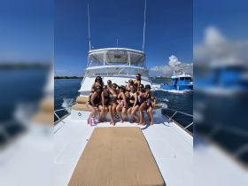 A lively group of friends enjoys a fun day on a yacht, celebrating together in the sun — perfect for memorable outings and parties on the water.