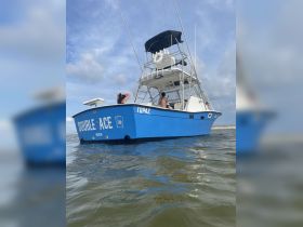 A vibrant fishing boat named 'Double Ace' is seen underway, with guests enjoying the day on the water — perfect for fishing adventures and leisure outings.