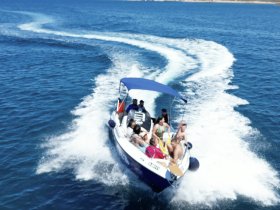 A lively group enjoys a day on the water aboard a speedboat, showcasing the excitement of summer adventures and on-water activities.