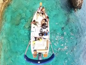 A lively group enjoys a day on the water aboard a boat, surrounded by stunning turquoise waters — perfect for a fun-filled adventure.