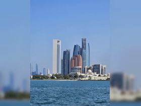 A stunning view of Abu Dhabi's skyline from the water, showcasing modern skyscrapers against a clear blue sky — perfect for capturing the essence of urban waterfront experiences.