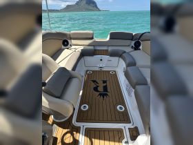 Interior view of a spacious boat seating area, featuring comfortable lounge seating and a stylish floor design, perfect for relaxing on the water.