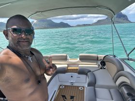 A man takes a selfie on a boat with stunning ocean views, showcasing a relaxed day on the water. Perfect for capturing memorable moments during boating adventures.