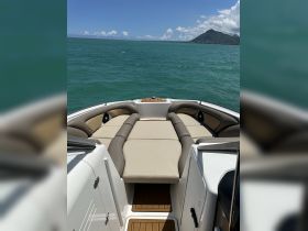 A spacious interior view of a boat's seating area, showcasing comfortable cushions and a sleek design, perfect for relaxing on the water.