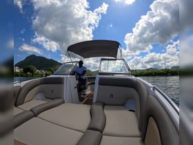 A view of the interior of a stylish boat, showcasing comfortable seating and the helm area, perfect for relaxing while navigating scenic waters.