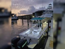 A sleek speedboat docked at sunset, showcasing its clean lines and modern design, perfect for fishing or leisure outings.