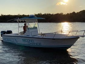 A Robalo boat named 'Second Chance' is seen cruising on calm waters at sunset, showcasing its sleek design and tranquil surroundings.