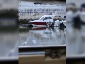 A view of a boat docked at a marina, showcasing its sleek design and tranquil surroundings.