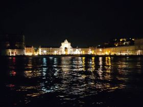 A stunning night view of a beautifully illuminated waterfront, showcasing the vibrant city lights reflecting on the water — perfect for romantic evening cruises.