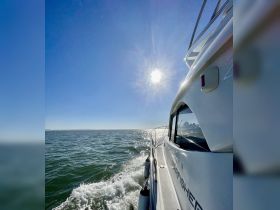 A stunning side view of a yacht cruising through sparkling waters under a bright sun, perfect for showcasing the beauty of boating adventures.
