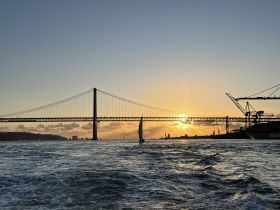 A stunning sunset view over a bridge, capturing the serene beauty of the water — perfect for scenic boat trips and photography.