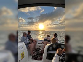 A group enjoys a beautiful sunset on a boat, creating a perfect backdrop for family memories and celebrations on the water.