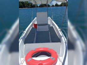 Interior view of a boat showcasing comfortable seating and a helm area, perfect for relaxing while enjoying the scenic waters.