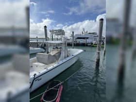 A sleek speedboat docked at the marina, showcasing its elegant design against a backdrop of clear skies and calm waters.