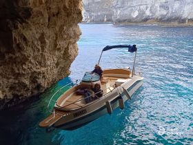 A small boat navigates through a stunning cave, showcasing the beauty of water exploration in a picturesque setting.