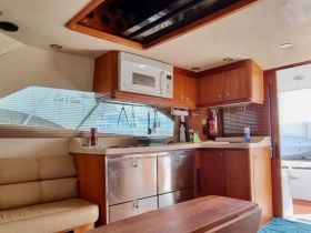 Interior view of a well-equipped boat cabin featuring a seating area and kitchen amenities, perfect for comfortable cruising.