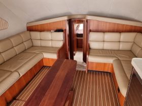 Interior view of a cozy boat cabin featuring comfortable seating and a warm wooden finish, perfect for relaxing during a day on the water.