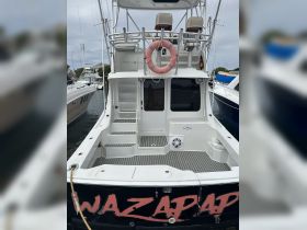 The rear view of the 'WAZARAP' yacht showcases its spacious deck and seating area, perfect for relaxing while docked.