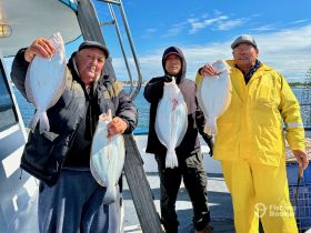 A group of fishermen proudly display their catch of flounder aboard a boat, showcasing the excitement of a successful fishing trip.