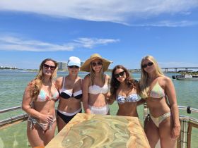 A vibrant group of friends enjoys a sunny day on the boat, showcasing their stylish bikinis and capturing the essence of summer fun on the water.
