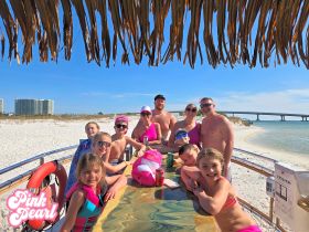 A joyful family gathers at the beach aboard the Pink Pearl, enjoying a sunny day filled with laughter and fun — perfect for memorable group outings.
