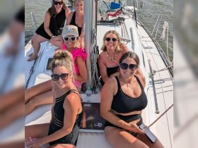 A lively group of friends enjoys a fun day sailing, showcasing camaraderie and celebration on the water.