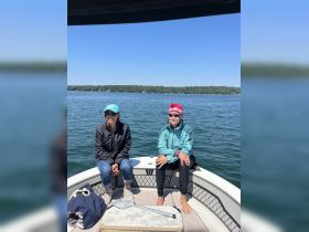 Two friends enjoy a sunny day on the boat, capturing the essence of relaxation and camaraderie on the water.