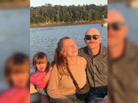 A joyful family enjoys a sunny boat ride, capturing a moment of laughter and happiness together on the water.