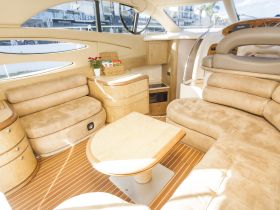 A beautifully designed interior of a boat featuring plush seating and a well-appointed helm area, perfect for relaxing while cruising on the water.