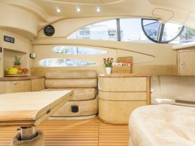 A beautifully designed interior of a boat featuring comfortable seating and a dining area, perfect for relaxing and enjoying meals while on the water.