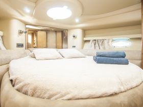 Cozy interior of a boat cabin featuring a round bed and plush seating, perfect for relaxing during a nautical getaway.