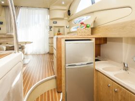 A well-appointed interior of a boat featuring a cozy seating area and kitchen amenities, perfect for relaxing and dining while on the water.