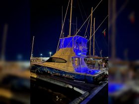 A striking view of a yacht illuminated in blue lights at night, docked and ready for evening adventures.