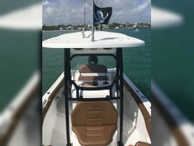 A view of the helm and seating area inside a boat, featuring a pirate flag and a sleek design, perfect for a day on the water.