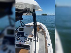A detailed view of the helm and seating area inside a sleek boat, showcasing modern controls and comfortable seating, perfect for a day on the water.