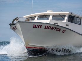 The 'Bay Hunter II' speeds through the water, showcasing its sleek design and powerful performance — perfect for fishing or adventure trips.