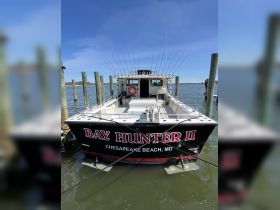 A striking view of the 'Bay Hunter II' fishing boat docked at Chesapeake Beach, MD, showcasing its robust design and fishing gear setup.