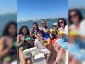 A joyful group of family and friends enjoy colorful snacks aboard a boat, perfect for creating lasting memories on the water.