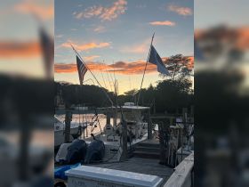 A serene sunset view of fishing boats docked at the marina, showcasing the peaceful atmosphere of a boating community.