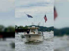 A fishing boat navigates through the water with a group onboard, showcasing a lively day on the water. Perfect for fishing enthusiasts and family outings.
