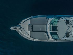Aerial view of a sleek boat showcasing its design and structure against a deep blue background, perfect for highlighting vessel features.