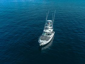 Aerial view of a sleek speedboat cruising through deep blue waters, showcasing its impressive design and perfect for thrilling adventures on the sea.