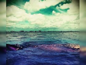 An unclear view of water and clouds, lacking identifiable features or subjects.