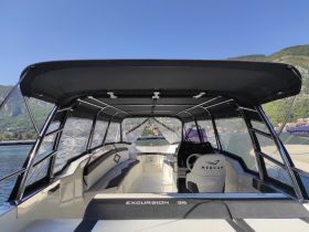Interior view of the helm area on a luxurious Excursion 36 boat, showcasing comfortable seating and modern design elements, perfect for a day on the water.