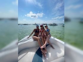 Three friends enjoy a sunny day on the boat, showcasing the perfect summer vibe and camaraderie on the water.