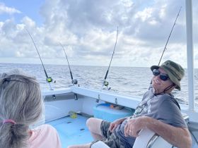 Two people enjoy a relaxing fishing trip on a boat, showcasing the joy of ocean adventures and camaraderie.