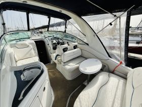 A spacious and stylish interior of a boat featuring comfortable seating and a well-equipped helm, perfect for relaxing on the water.