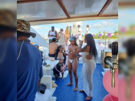 A lively group enjoys a festive atmosphere aboard a boat, celebrating with drinks and decorations — perfect for parties and special occasions on the water.