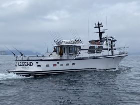 The fishing vessel 'Legend' navigates the waters near Seward, AK, showcasing its robust design and fishing gear, perfect for adventurous outings.