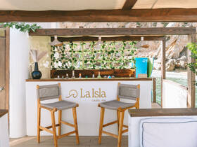 A beautifully designed interior bar area on a boat, featuring stylish seating and a selection of drinks, perfect for relaxing and enjoying the scenic views.